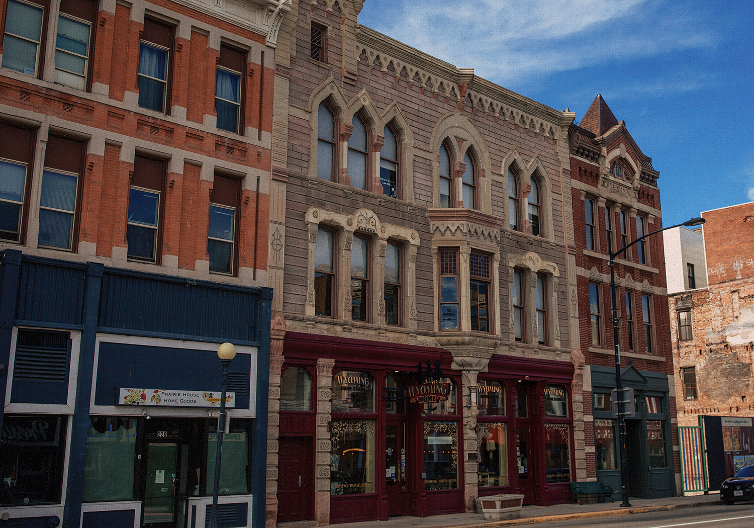 A row of historic buildings display colorful stone and brickwork.