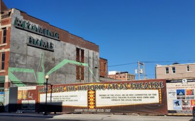 THE HOLE A large banner extends the length of a chain link fence, displaying an ad for "Save the Historic Atlas Theatre."
