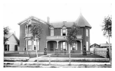 NAGLE-WARREN-MANSION-FIRST-RENDITION A street view of a historic mansion, with four people posing in the front yard.