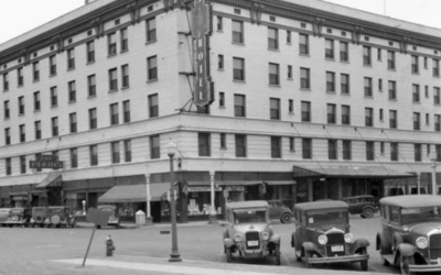 PLAINS-HOTEL A historic photo of the Plains Hotel in Downtown Cheyenne, with a row of cars parked outside.