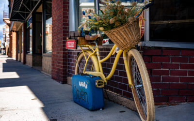Leaning Bike An old-fashioned bike leans against a brick wall outside of a downtown business.