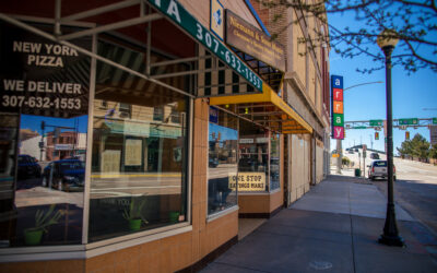 Sidewalk – Downtown A street view of downtown Cheyenne, showing awnings and windows for several businesses.