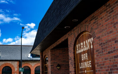 The Albany Street view of The Albany, with a wooden sign on the building.