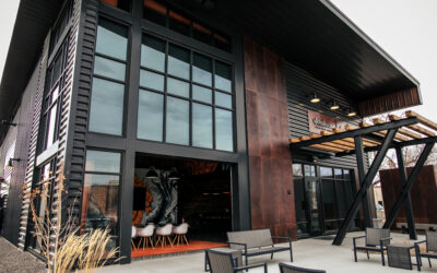Warehouse 21 Horizontal exterior of Warehouse 21, with open garage door and patio furniture outside.