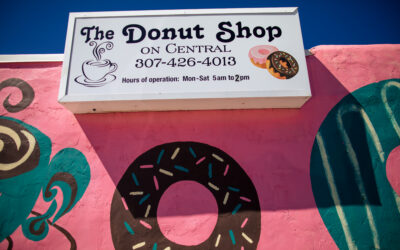 The Donut Shop Exterior signage for The Donut Shop, a pink building painted with donuts
