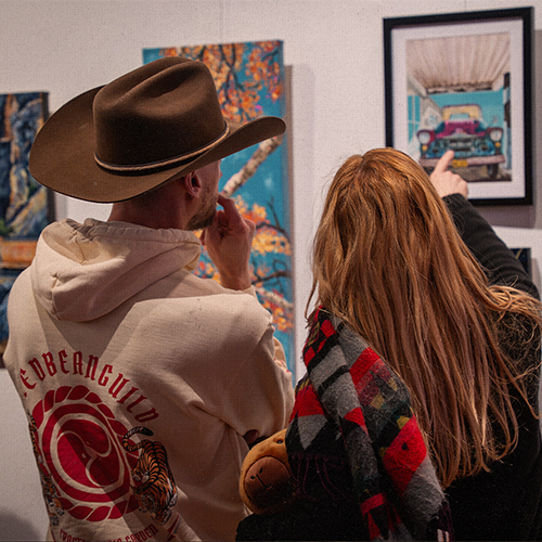 Two people in an art gallery admiring art