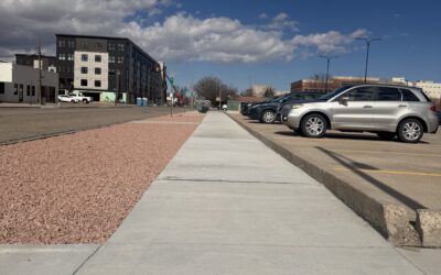 HEALTH WORKS ONEIL A sidewalk travels between decorative gravel and a parking lot.