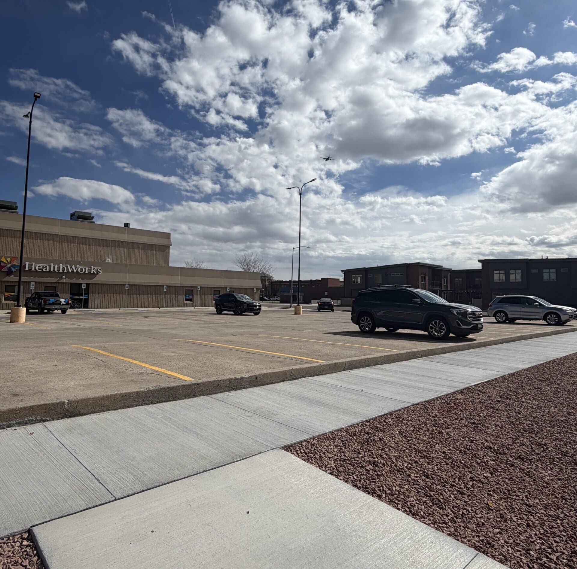 Exterior of HealthWorks building, showing the parking lot and sidewalk.